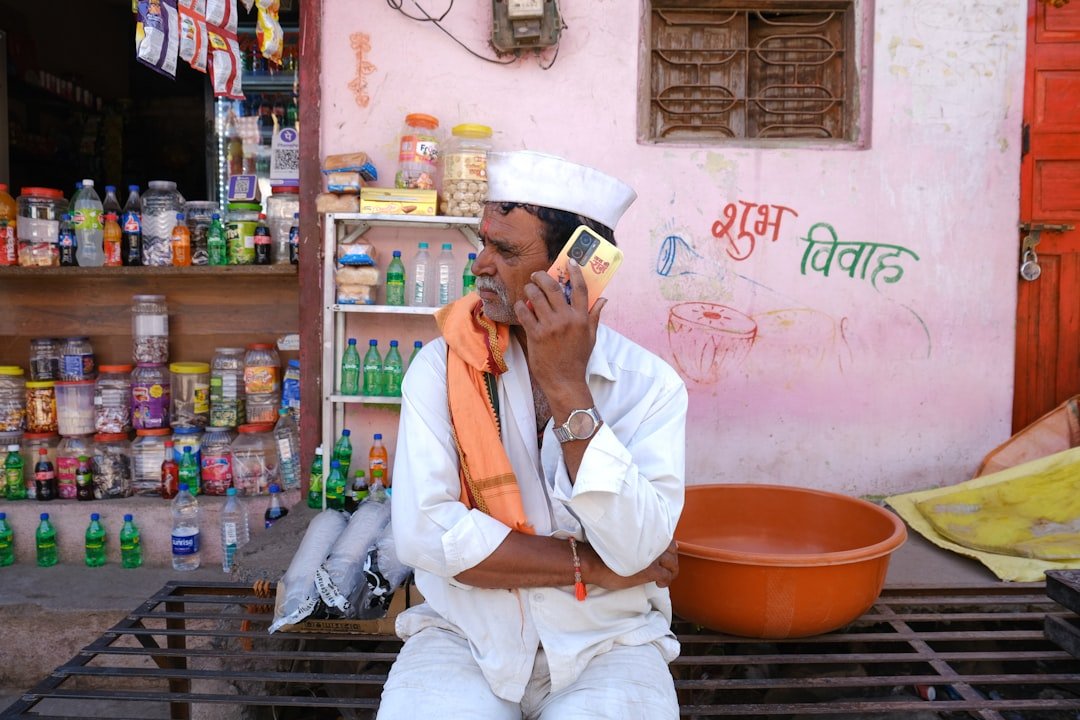 Man in traditional indian attire talking on phone.