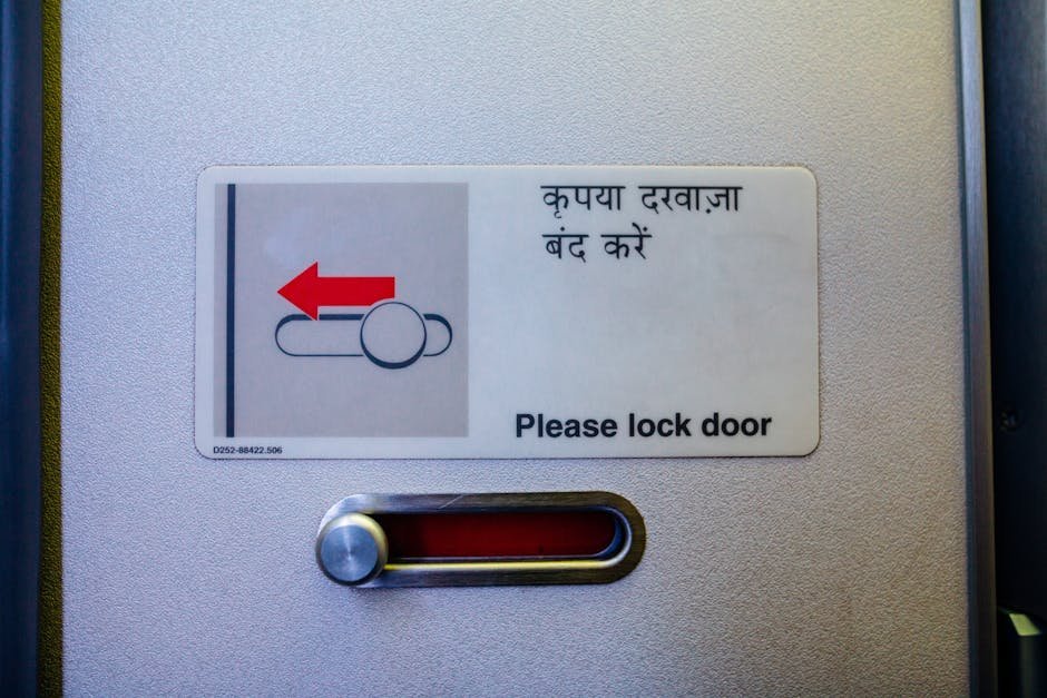Detailed view of a 'Please lock door' sign with Hindi translation.