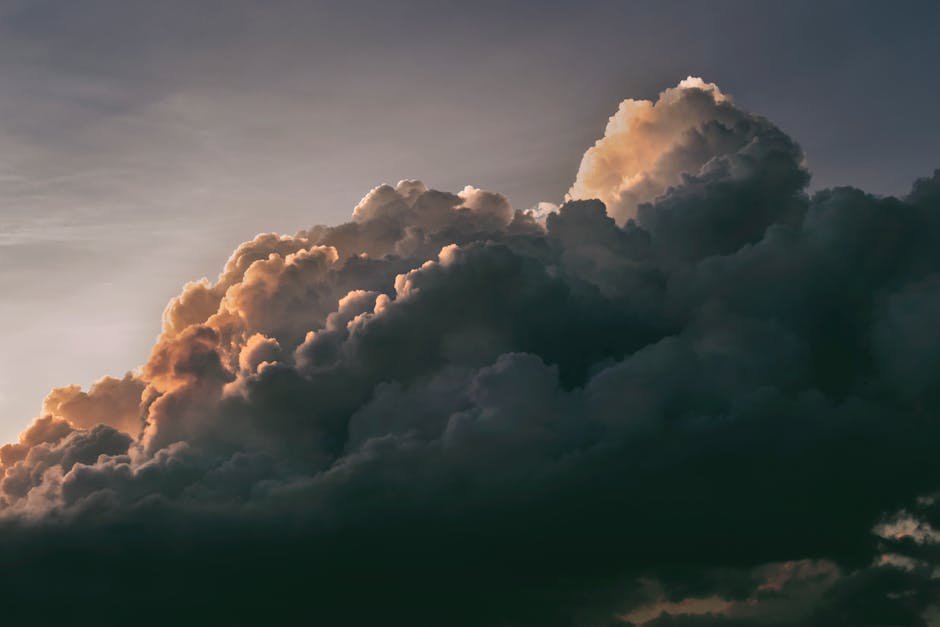 A beautiful and dramatic cloudscape with warm sunlight peeking through at twilight, creating a serene sky.