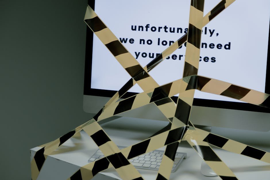 A computer screen taped and displaying a termination message, symbolizing unemployment.