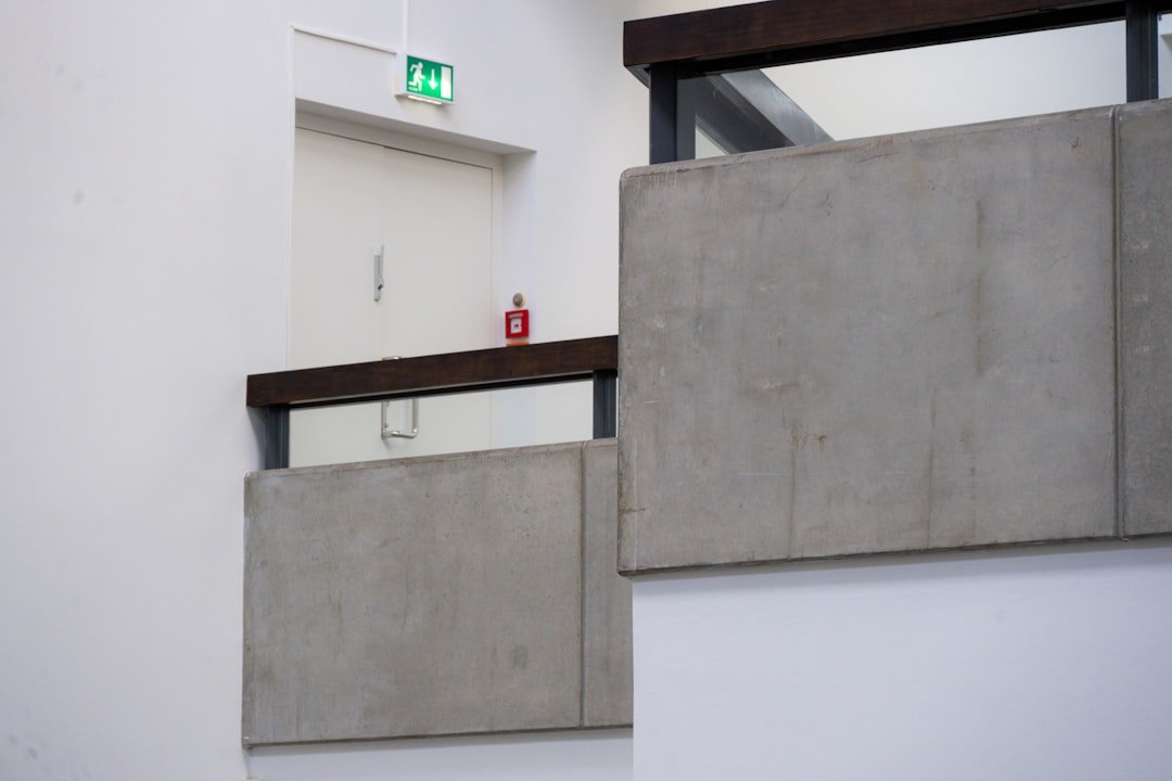 Modern concrete and wood interior with emergency exit sign.