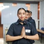 Women in uniform greet with hands pressed together.