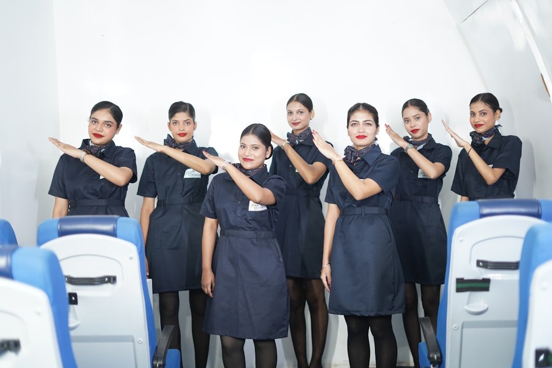 Flight attendants in uniform gesturing inside airplane