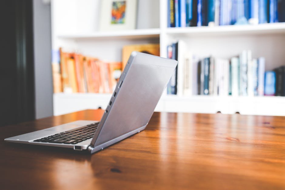 Elegant laptop on a wooden desk in a well-organized modern home office environment, perfect for remote work inspiration.