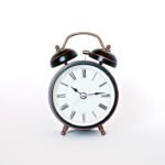 round black and white analog alarm clock