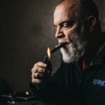 a man with a beard is smoking a cigarette