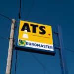 a sign for a gas station with a blue sky in the background