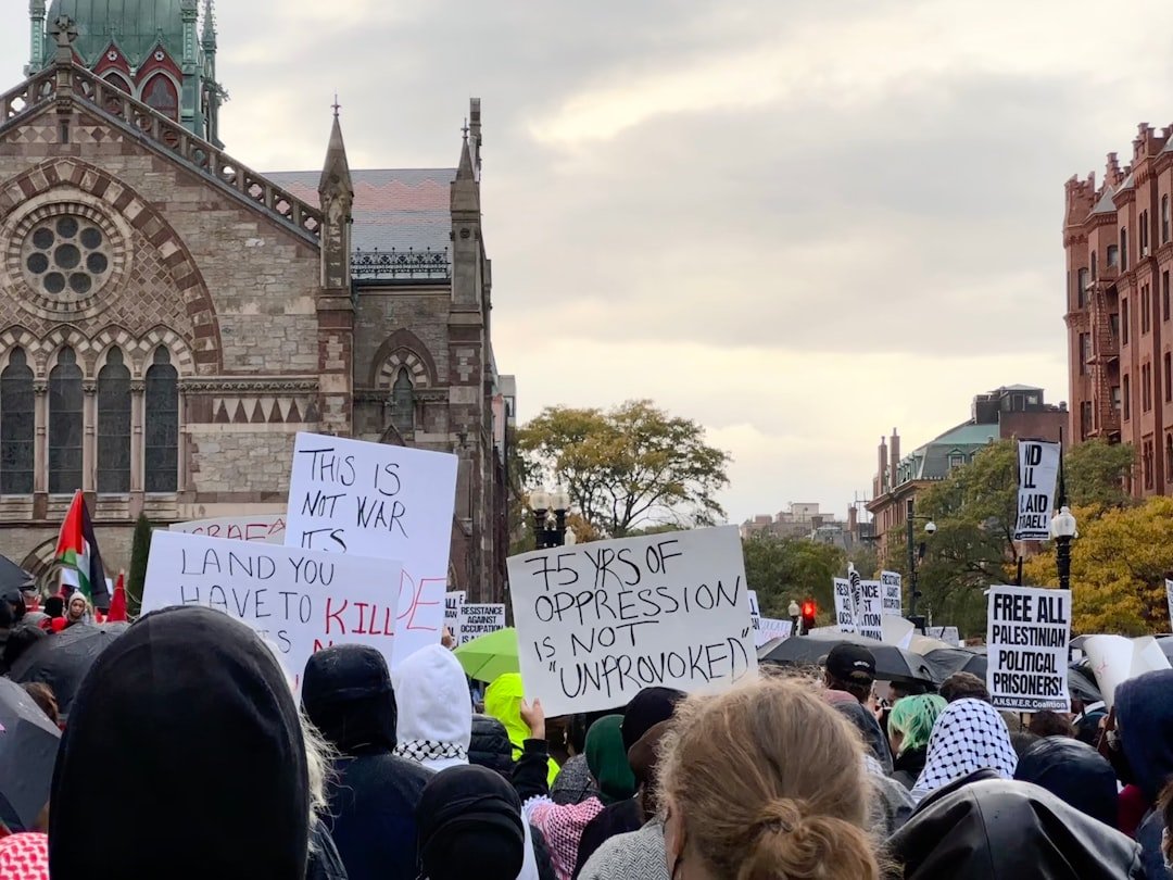 a crowd of people holding signs in front of a church