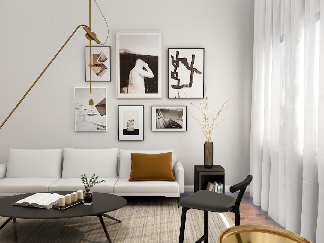 A white sofa with a mustard pillow in a living room with framed art